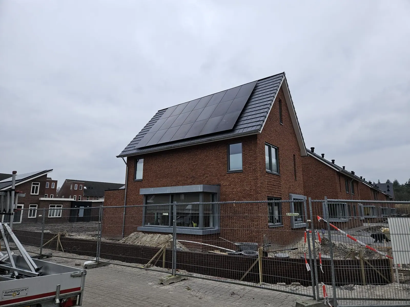 Nieuwbouwwoning met zwarte zonnepanelen op het schuine dak